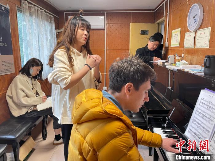 伊利亚(前)与同事交流教学。 受访者供图 伊利亚(前)与同事交流教学。 受访者供图