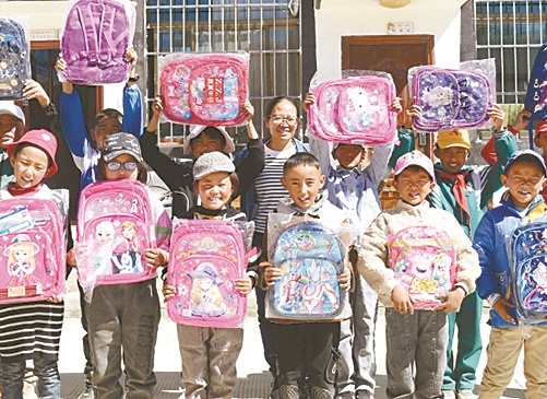 张晓敏和收到爱心书包的孩子们合影。.jpg 张晓敏和收到爱心书包的孩子们合影。.jpg