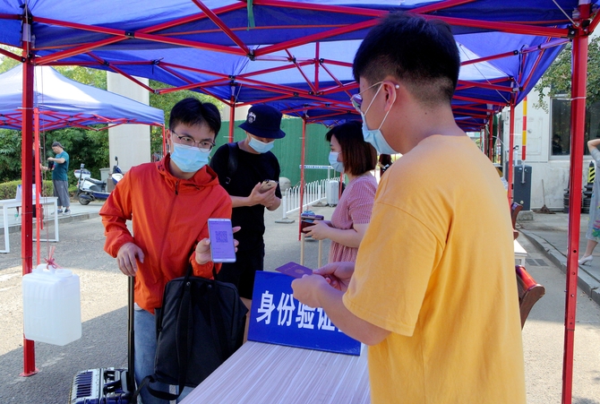 返校学生在进校通道进行身份核验 返校学生在进校通道进行身份核验